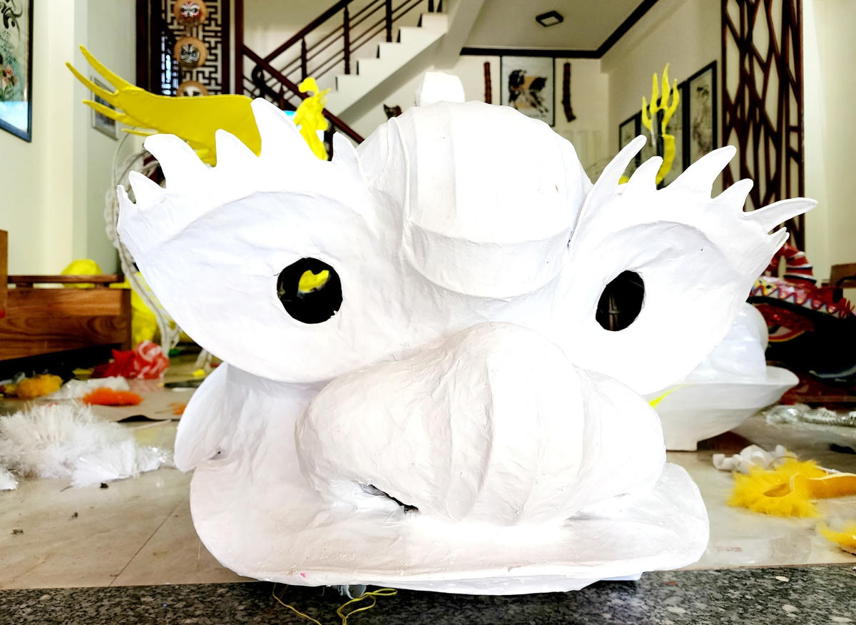 Một đầu Lân đã được dán giấy xong nhưng chưa vẽ trang trí.
