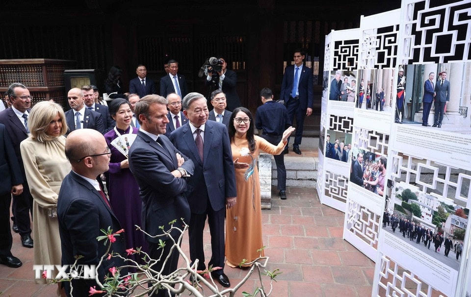 Tổng Bí thư Tô Lâm và Phu nhân cùng Tổng thống Pháp Emmanuel Macron và Phu nhân xem trưng bày ảnh về những dấu mốc tiêu biểu trong quan hệ giữa hai nước, do Thông tấn xã Việt Nam thực hiện. (Ảnh: Thống Nhất/TTXVN)