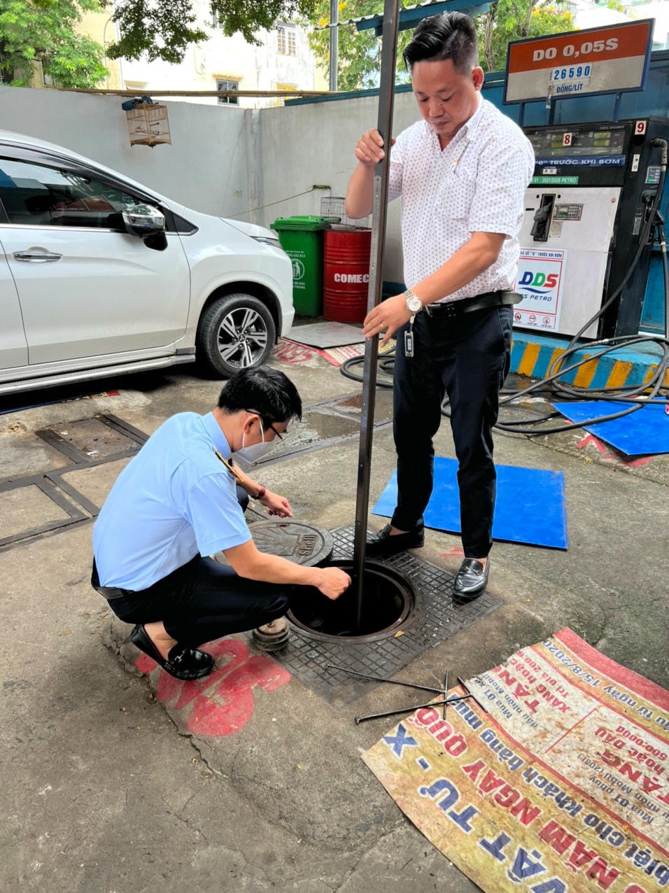 Lực lượng chức năng kiểm tra xăng dầu tại những chưa hàng treo biển báo hết xăng.