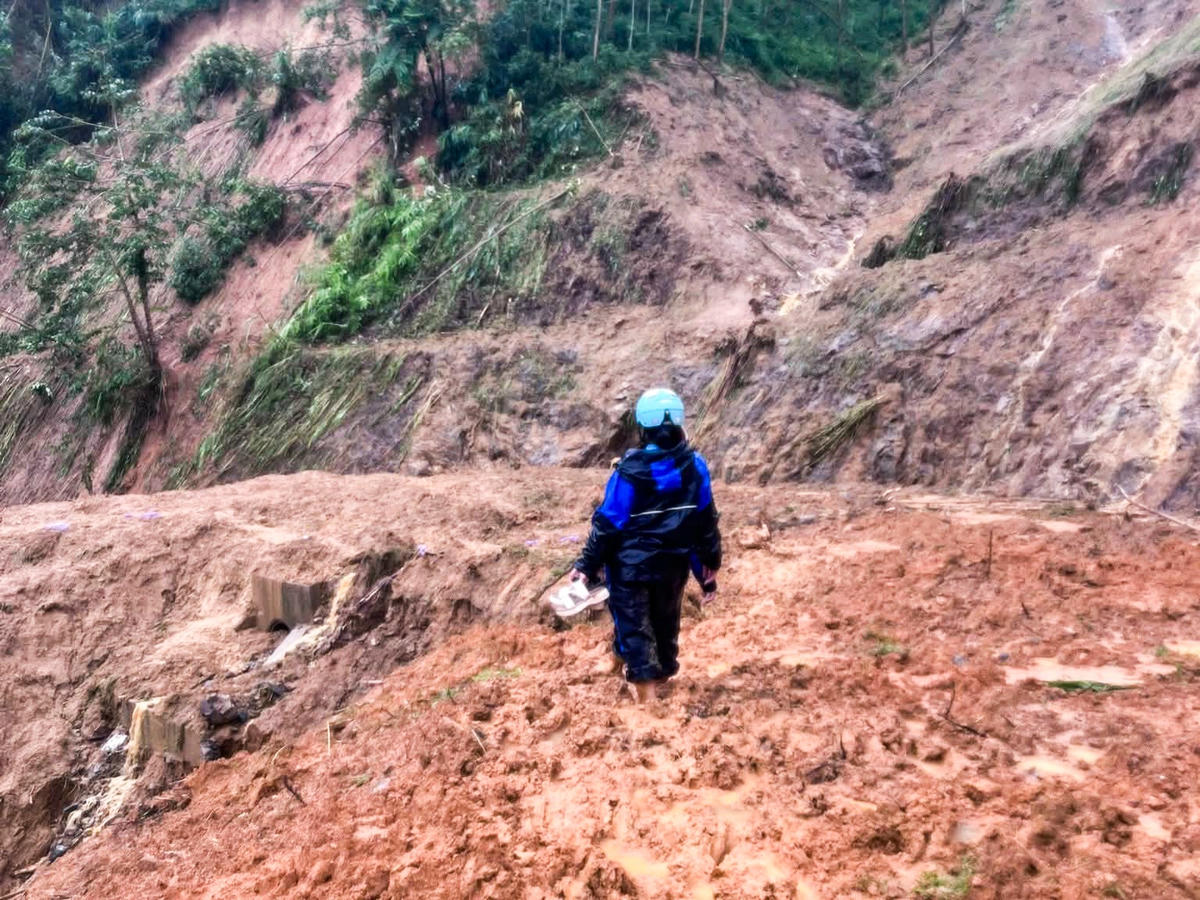 Người dân bản Dưn (xã Bát Mọt) vượt qua các điểm sạt lở sáng 28/8 để nhận nhu yếu phẩm cứu trợ ở xã Yên Nhân. Ảnh: Thường Xuân