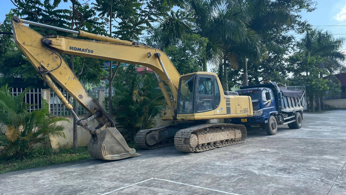 Chiếc máy xúc và ô tô bị bắt được để tại UBND xã Hùng Xuyên vào chiều 12/7. Ảnh: Ngô Hùng