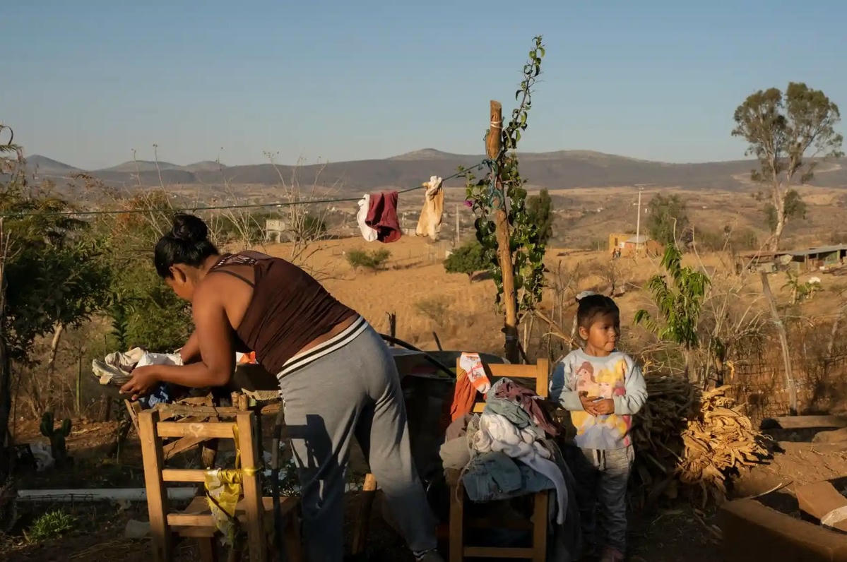Azucena Asunción Martínez Sántos rửa bát trong sân nhà của cô ở Mogote Colorado với con gái của cô, Wendy Crespo Martínez.