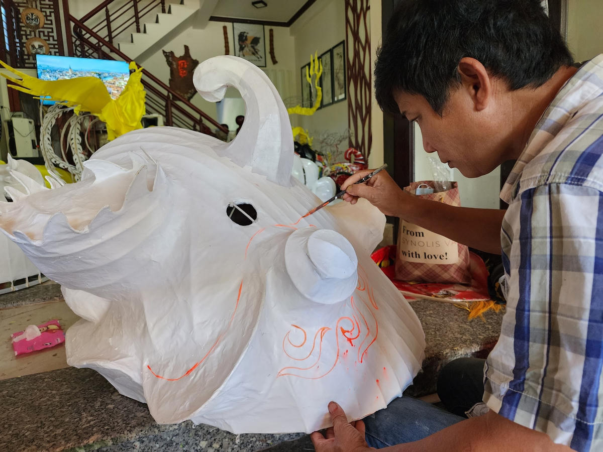 Anh Nguyễn Hưng tỉ mỉ vẽ hoa văn cho đầu Lân.