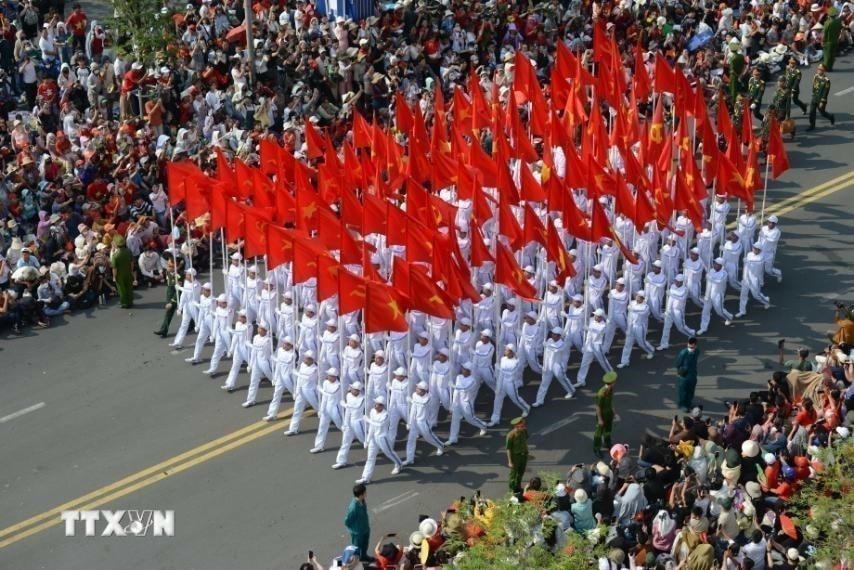 Khối cờ Đảng, cờ Tổ quốc diễu hành trên đường Nam Kỳ Khởi Nghĩa. (Ảnh: TTXVN)