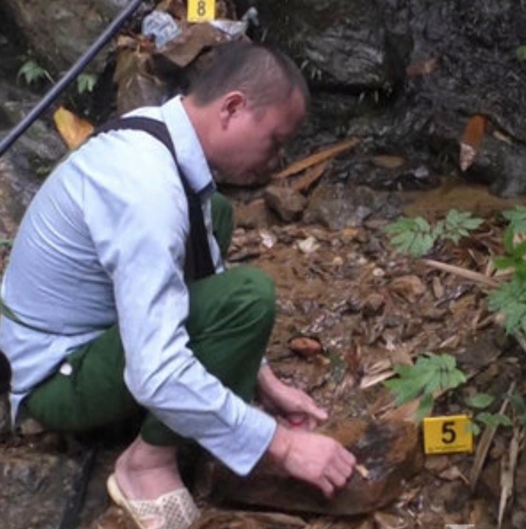 Đối tượng Đặng Tài Chu đang thực nghiệm lại hành vi dùng thuốc trừ cỏ đầu độc nguồn nước của 4 hộ cùng thôn