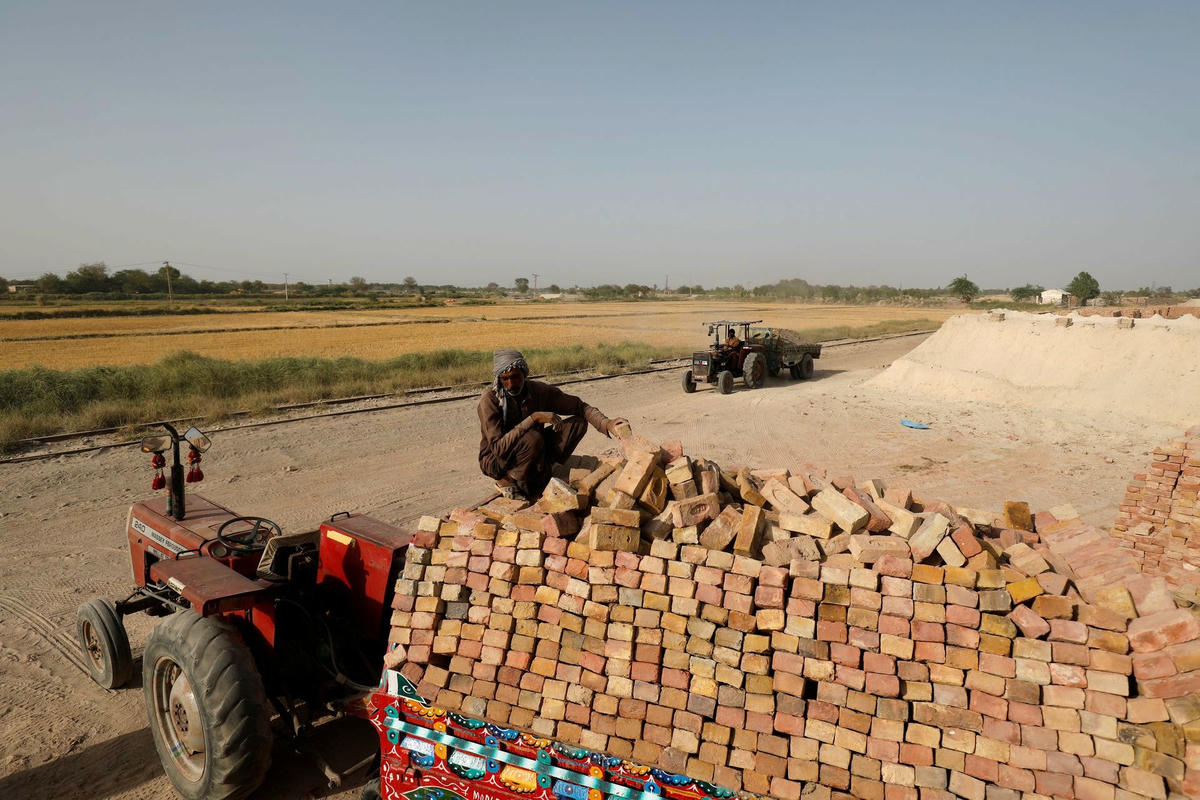 Những người đàn ông làm việc ngoài trời ở Jacobabad. Ảnh: Reuters.