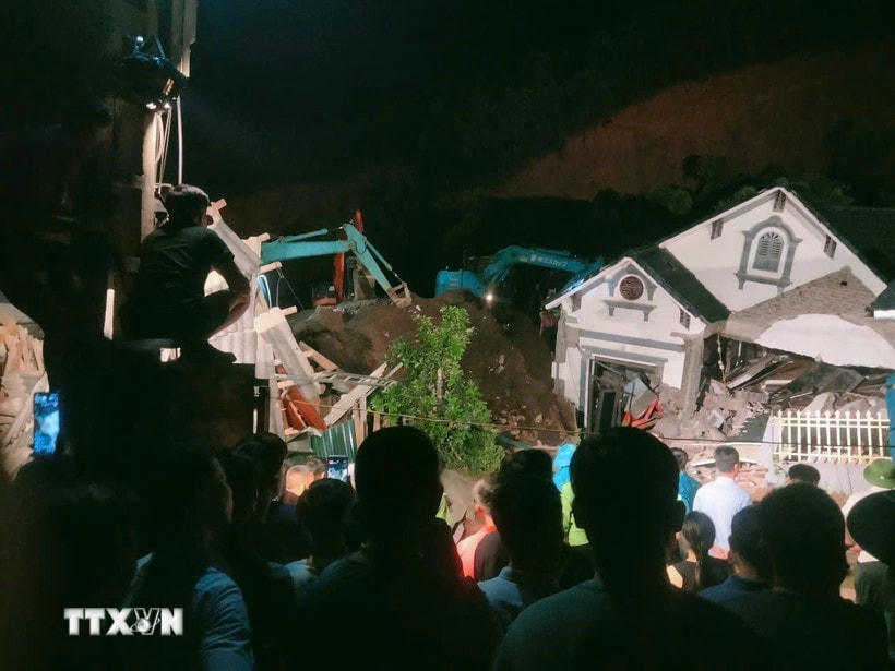 Lực lượng chức năng và người dân tổ chức tìm kiếm nạn nhân bị vùi lấp. (Ảnh: TTXVN phát)