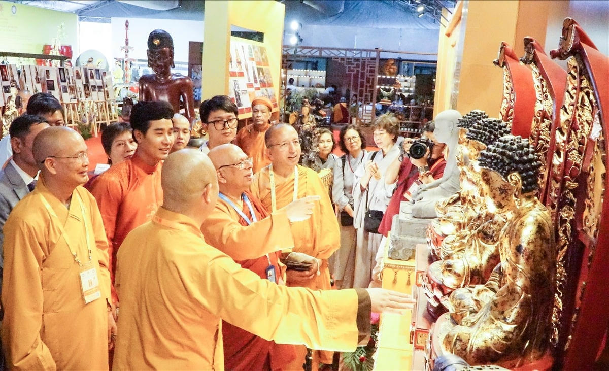 Các đại biểu tham quan một số phiên bản mô phỏng của bảo vật quốc gia thuộc Phật giáo Việt Nam được chế tác trưng bày tại triển lãm (Ảnh T.Đ).