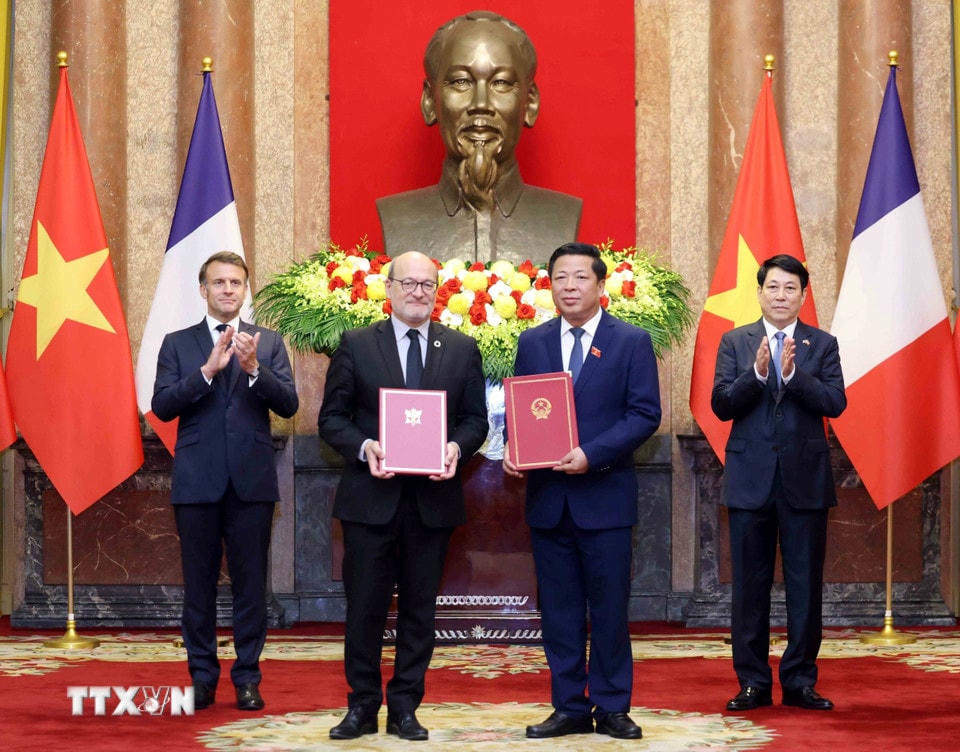 Bộ trưởng Bộ Xây dựng Trần Hồng Minh và Tổng Giám đốc Cơ quan Phát triển Pháp (AFD) Rémy Rioux trao đổi Ý định thư giữa Bộ Xây dựng Việt Nam và Bộ Giao thông Pháp về thúc đẩy hợp tác trong lĩnh vực giao thông vận tải. (Ảnh: Lâm Khánh/TTXVN)