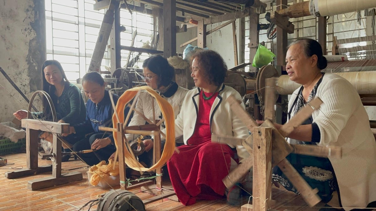 Khách du lịch trải nghiệm công đoạn dệt vải ở làng dệt Phùng Xá (Mỹ Đức). - Ảnh: Phạm Sỹ.