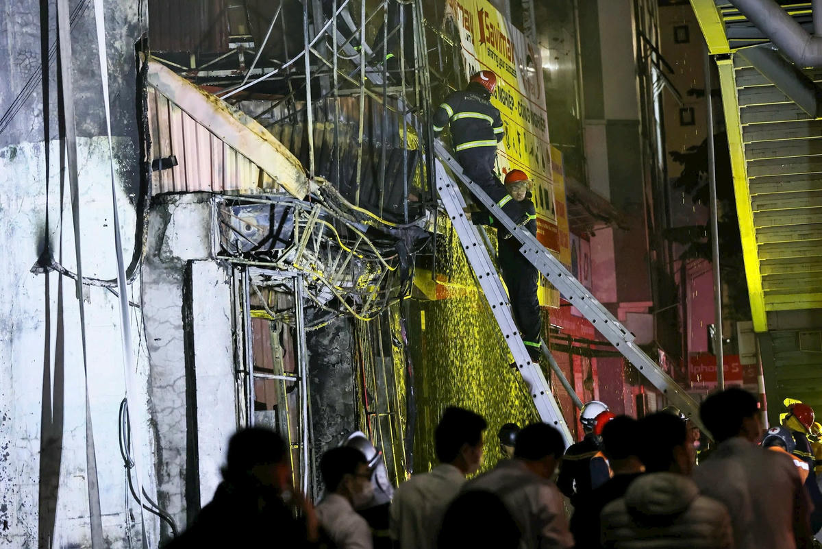 Lực lượng chức năng dùng thang tiếp cận hiện trường vụ cháy. Ảnh: Quang Vinh.