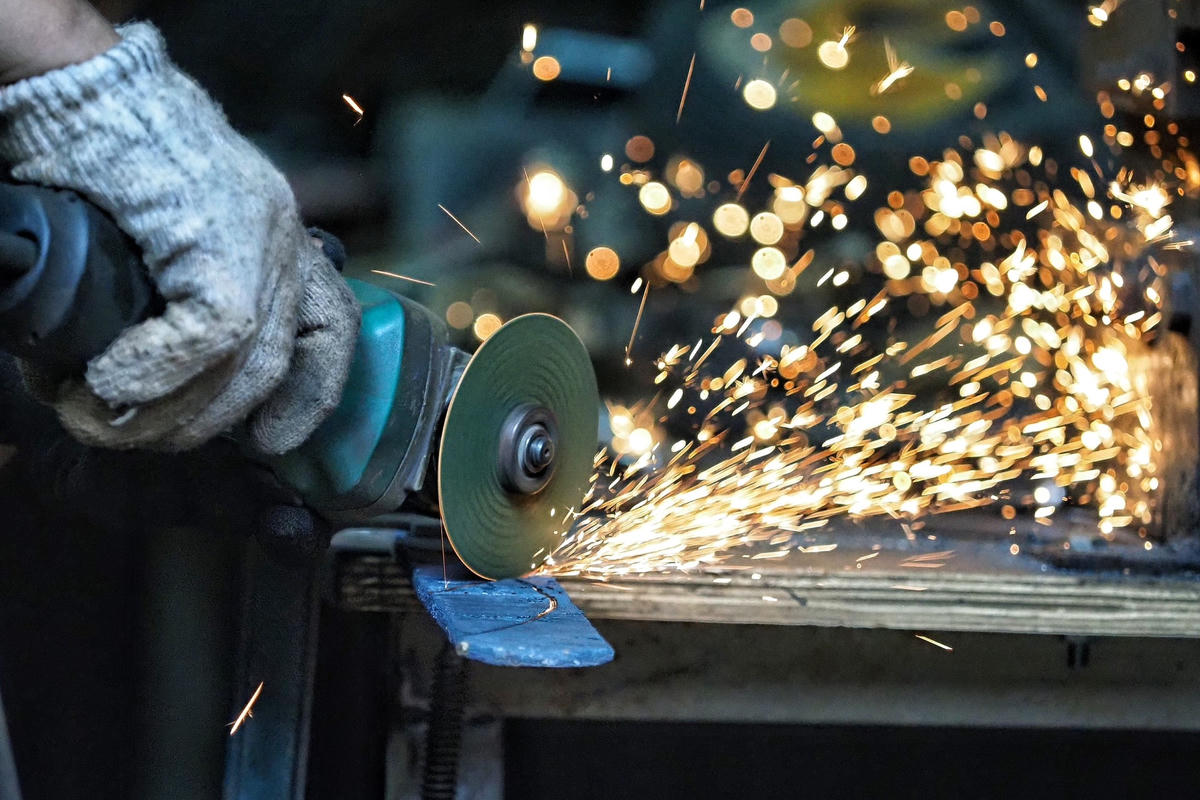 Từ nhiều miếng thép được đập bẹt, anh Chiến sử dụng máy cắt để tạo hình cho dao.