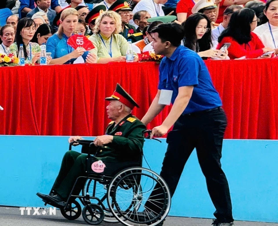 Thanh niên hỗ trợ đại biểu di chuyển trong khu vực Lễ diễu binh, diễu hành kỷ niệm 50 năm Ngày Giải phóng miền Nam, thống nhất đất nước. (Ảnh: Tấn Đạt/TTXVN)