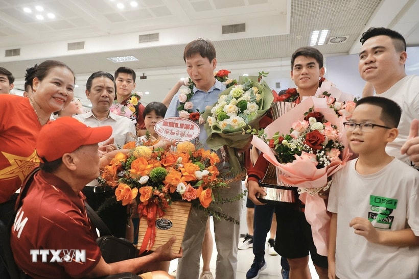 Người hâm mộ tặng hoa thầy trò huấn luyện viên Kim Sang Sik. (Ảnh: Minh Quyết/TTXVN)