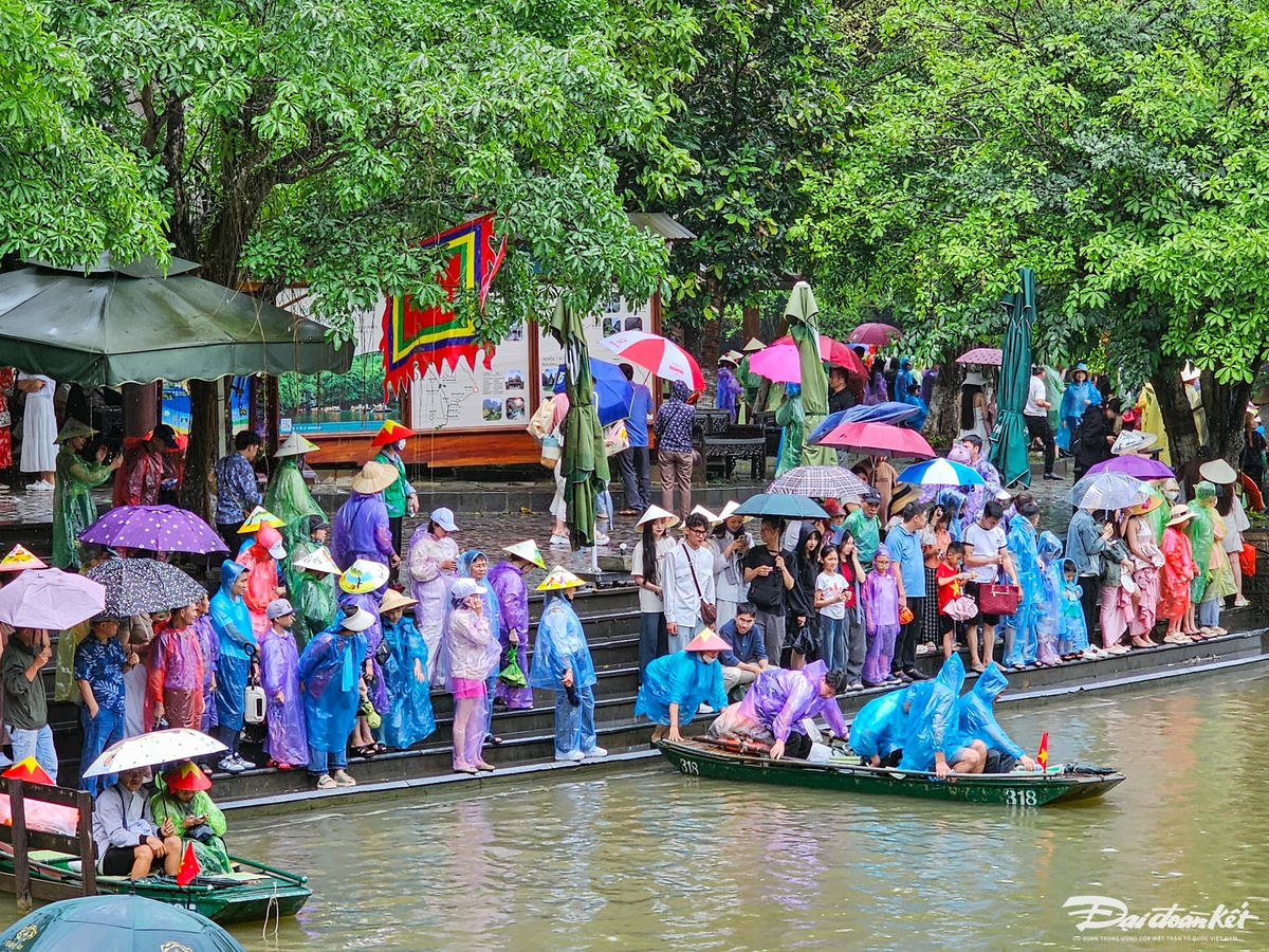 Tại bến đò sông Sào Khê, du khách mặc áo mưa, xếp hàng để chờ lên thuyền. Ảnh: Đình Minh