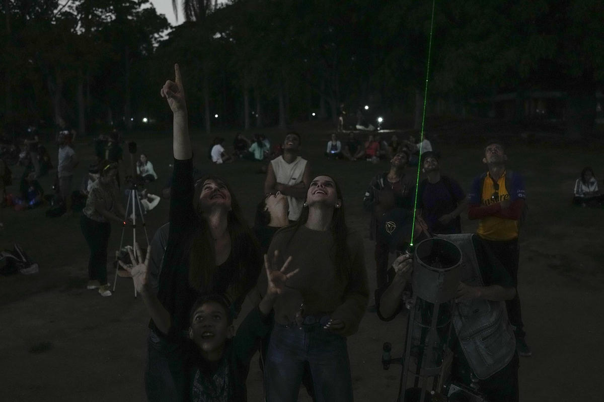 Người dân ngắm nhìn Mặt trăng trong tuần trăng máu đầu tiên trong năm ở Caracas, Venezuela. Ảnh: AP.