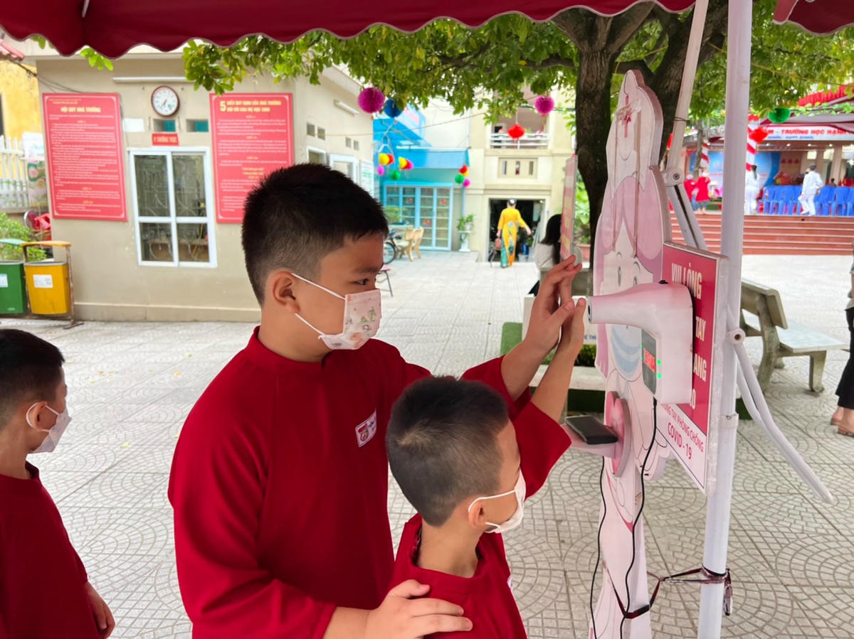 Các em học sinh đo thân nhiệt trước khi vào trường