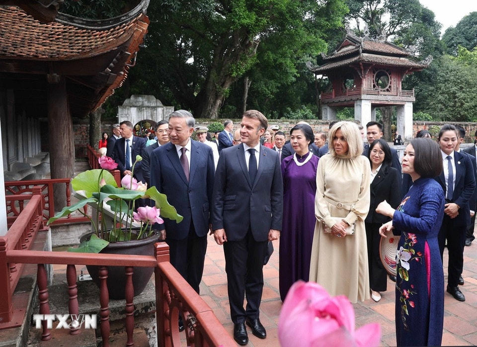 Tổng Bí thư Tô Lâm và Phu nhân cùng Tổng thống Pháp Emmanuel Macron và Phu nhân nghe giới thiệu về 82 bia Tiến sỹ - Di sản tư liệu thế giới. (Ảnh: Thống Nhất/TTXVN)
