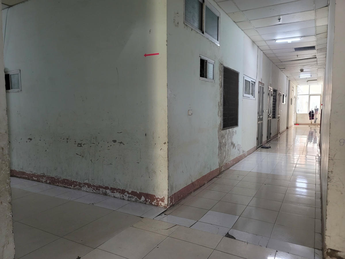 Bên trong toà nhà xuống cấp: tường rạn nứt, sơn bong tróc, ẩm mốc, gạch lát hư hỏng.
