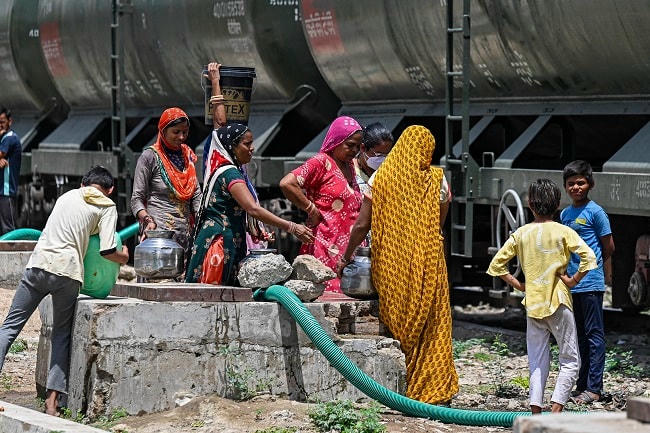 Phụ nữ và trẻ em xếp hàng lấy nước. Ảnh: Barron.