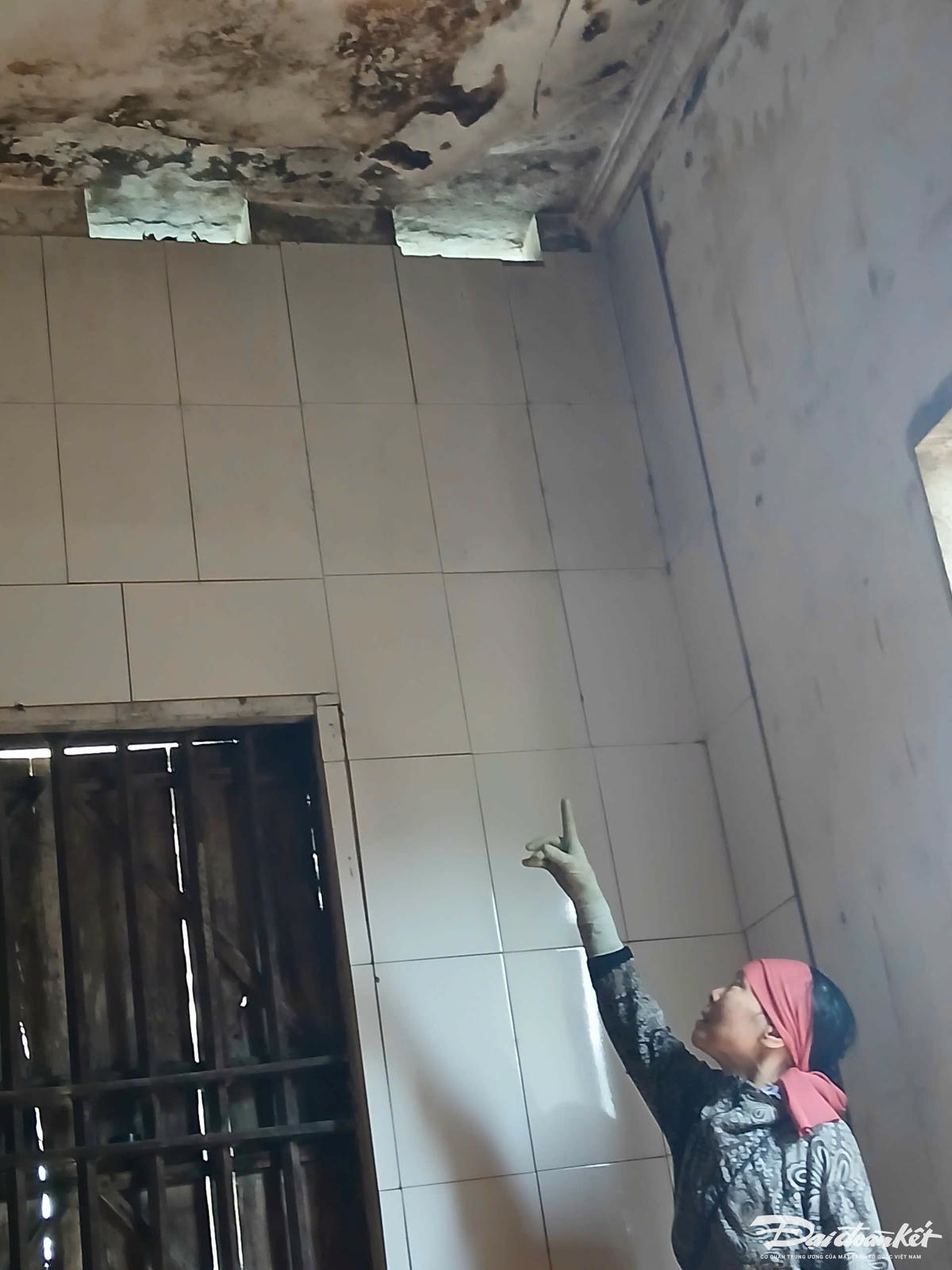 Bà Tình chỉ tay lên góc trần nhà đã bị nứt nhưng không được xây mới.