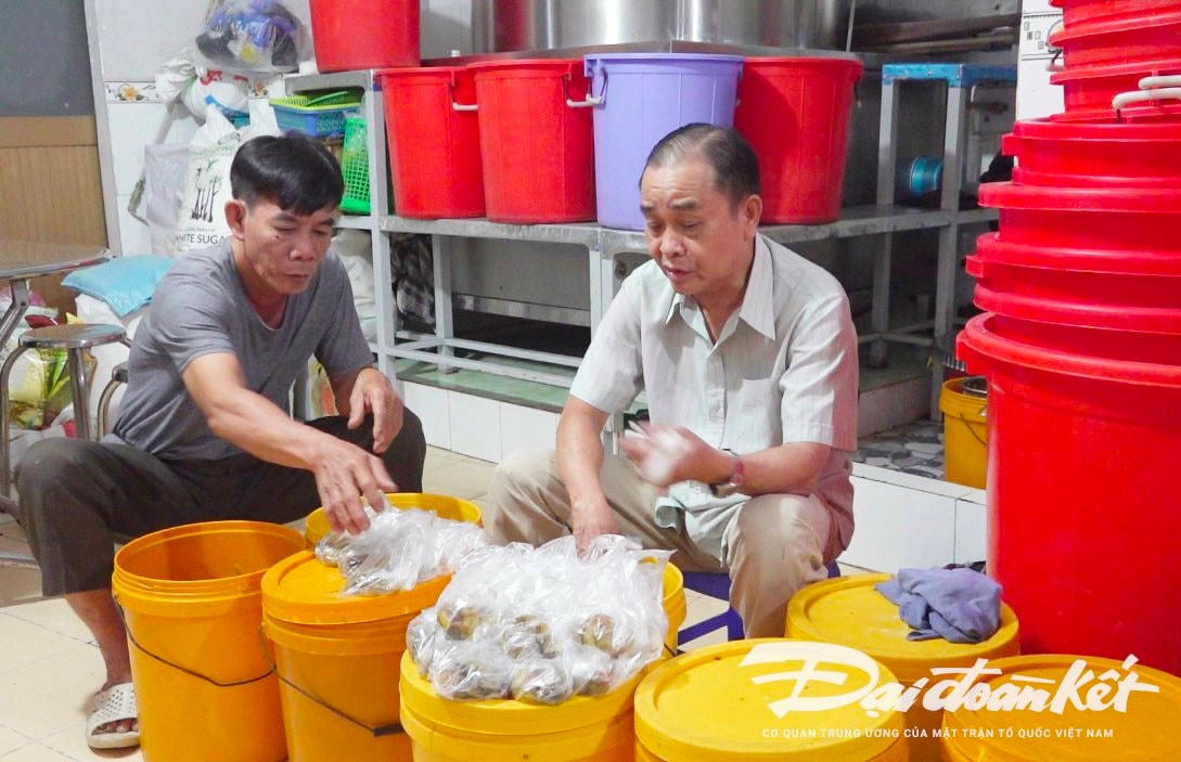 Ông Lữ Văn Thư và ông Ông Phan Ngọc Thạch đang phân chia các phần dưa mắm ăn kèm với cháo