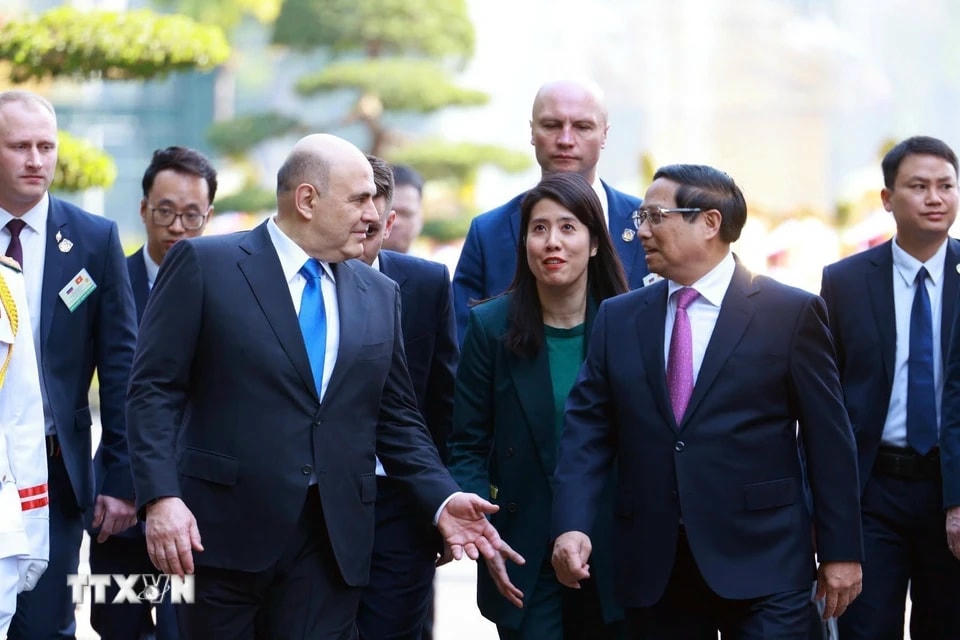 Thủ tướng Phạm Minh Chính và Thủ tướng Liên bang Nga Mikhail Vladimirovich Mishustin trao đổi thân mật. (Ảnh: Dương Giang/TTXVN)