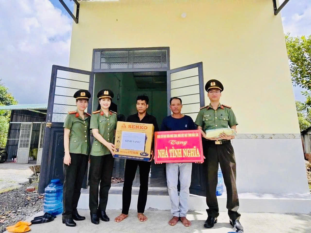 Đại diện Công an tỉnh bàn giao nhà và tặng quà cho bà con. Ảnh Thanh Nga