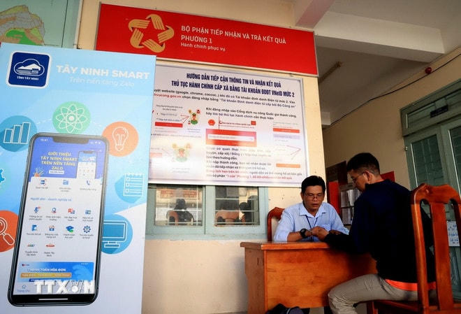Cán bộ phương ở Tây Ninh hướng dẫn người dân sử dụng tài khoản Dịch vụ công Quốc gia. (Ảnh: Hồng Đạt/TTXVN) ttxvn-tay-ninh-3.jpg
