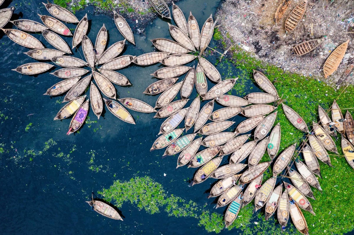 Hàng trăm chiếc thuyền gỗ chở công nhân từ ngoại ô thành phố vào trung tâm làm việc giống như những bông hoa ở cảng sông của Dhaka. Ảnh: Rex.