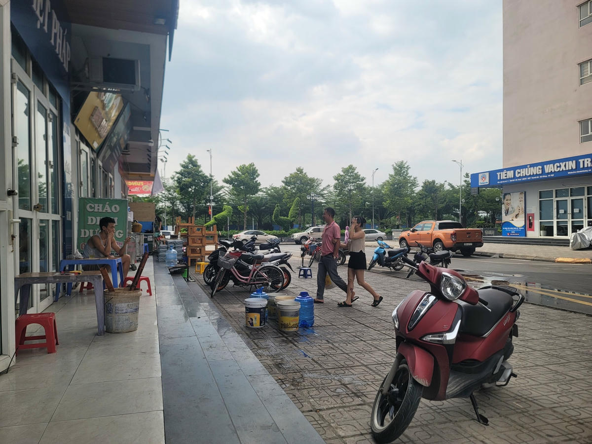 Nhiều người đặt sẵn xô, chậu ngồi uống trà đá hàng giờ đồng hồ chờ lấy nước.