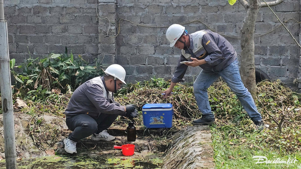 Đơn vị quan trắc tiến hành lấy mẫu nước tại vườn nhà anh Phạm Huy Nam để phân tích chất lượng. Ảnh: Phương Thanh.