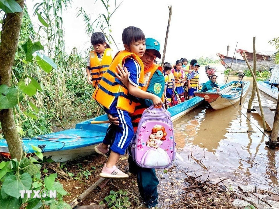 Lực lượng dân quân tự vệ xã Vĩnh Hội Đông (An Giang) chịu trách nhiệm đưa đón các học sinh Trường tiểu học B Vĩnh Hội Đông ở 2 ấp Vĩnh Hòa và Vĩnh An về nhà an toàn trong mùa mưa lũ, tháng 10/2022. (Ảnh: Công Mạo/TTXVN)