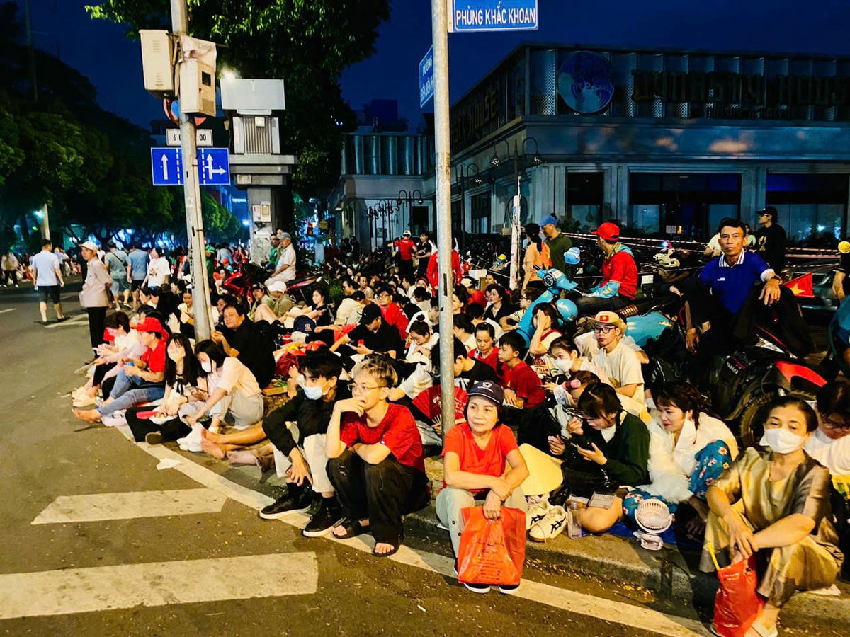 Rất đông người dân ngồi chờ trên trên vỉa hè đường Phùng Khắc Khoan để chứng kiến thời khắc trọng đại.
