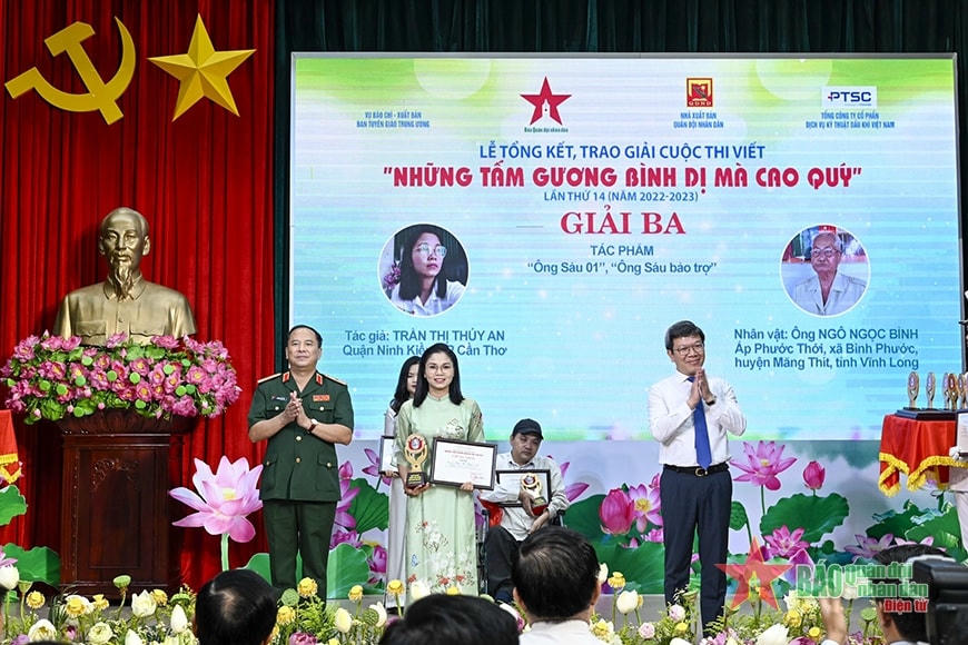 Thiếu tướng Đoàn Xuân Bộ, Tổng biên tập Báo Quân đội nhân dân, Trưởng Ban tổ chức cuộc thi và đồng chí Tống Văn Thanh, Vụ trưởng Vụ Báo chí - Xuất bản/Ban Tuyên giáo Trung ương, đồng Trưởng ban tổ chức cuộc thi trao giải ba cho các tác giả. Ảnh: qdnd.vn.
