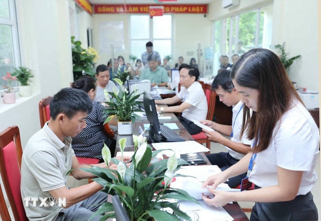 Người dân làm thủ tục hành chính tại trụ sở UBND phường Long Biên, số 199 Bát Khối, Hà Nội. (Ảnh: Thành Phương/TTXVN) ttxvn-chinh-quyen-2-cap-di-vao-hoat-dong-0407-2.jpg