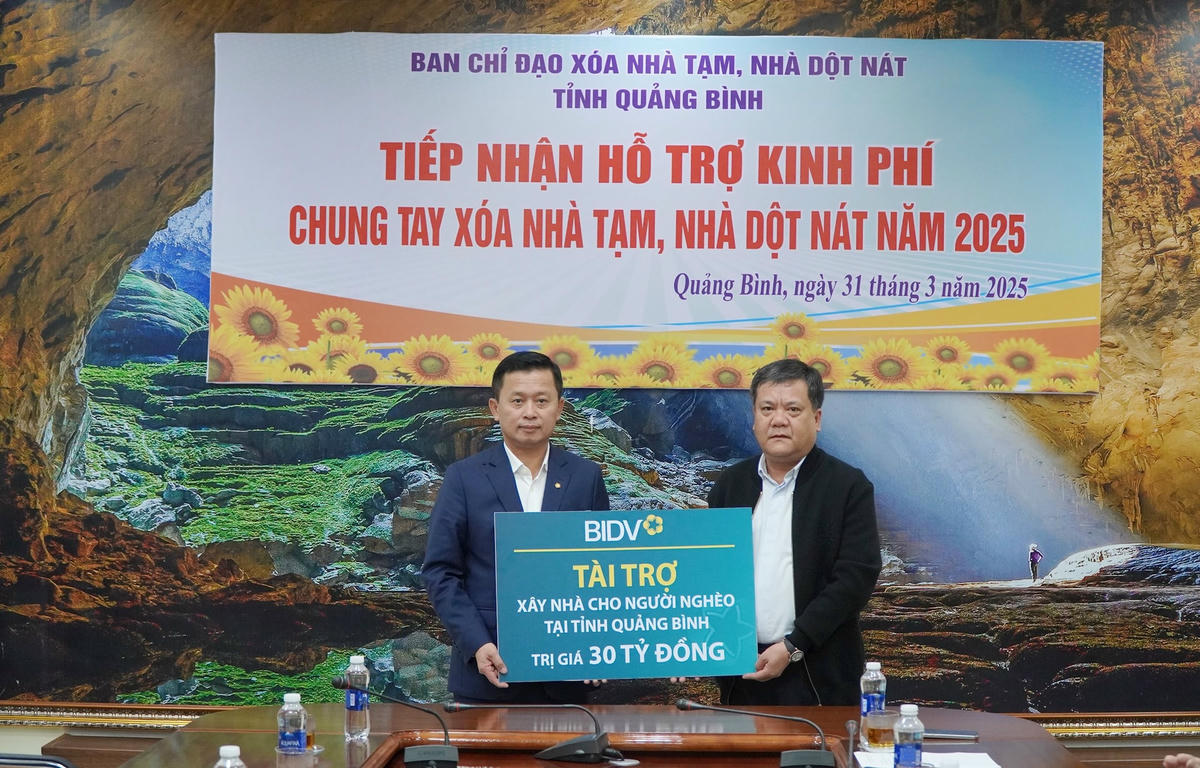 Ông Hoàng Việt Hùng, Phó Tổng Giám đốc Ngân hàng BIDV trao biển tượng trưng tài trợ 30 tỉ đồng chung tay xóa nhà tạm, nhà dột nát. Ảnh: Xuân Thi