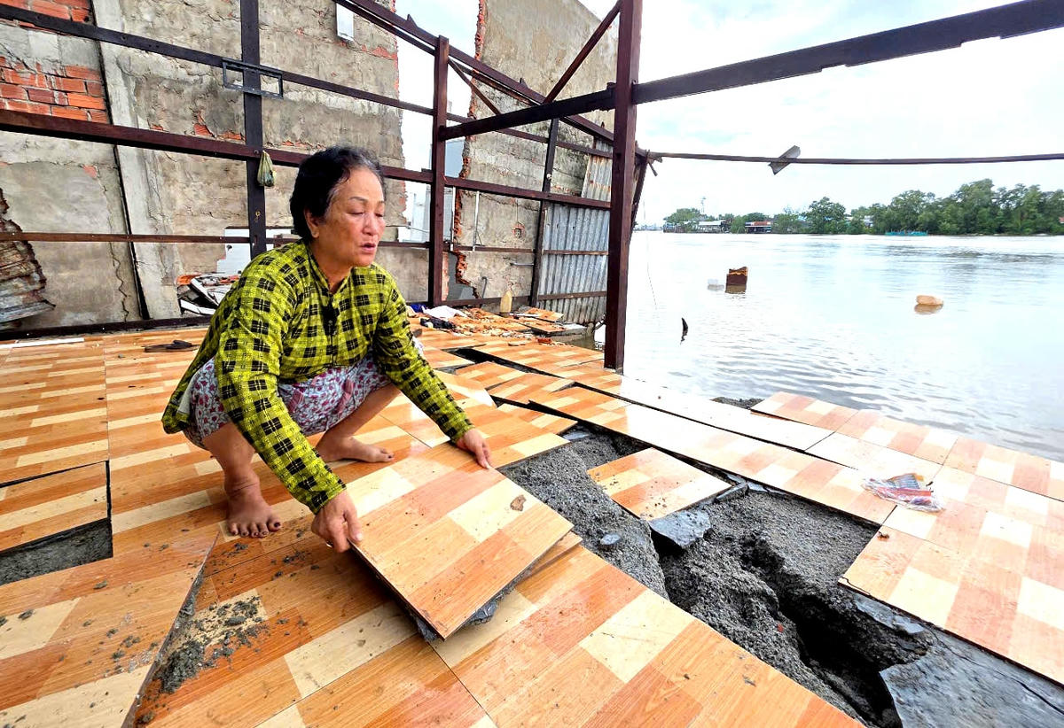 ẢNH 2 Bà Hoa gỡ những miếng gạch của căn nhà còn sót lại sau vụ sạt nghiêm trọng. Ảnh Nguyên Du.