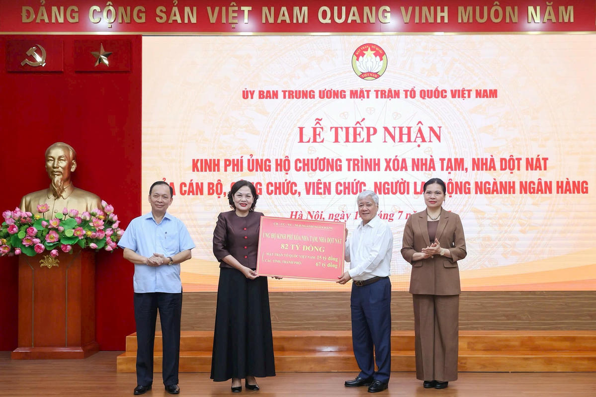 Chủ tịch Đỗ Văn Chiến tiếp nhận kinh phí ủng hộ chương trình xóa nhà tạm, nhà dột nát của cán bộ, công chức, viên chức, người lao động ngành Ngân hàng. Ảnh