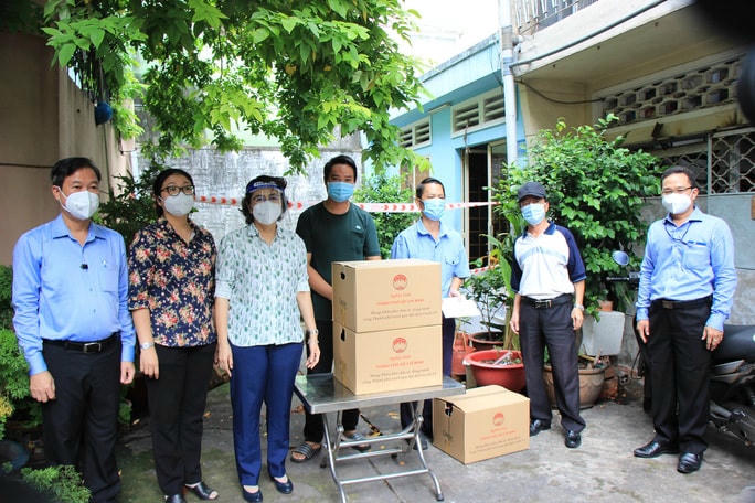 Chủ tịch Ủy ban MTTQ TP HCM Tô Thị Bích Châu (thứ 3 từ trái sang) tặng quà cho hộ lao động khó khăn trong khu trọ trên địa bàn.