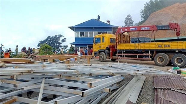 Lực lượng chức năng tháo dỡ công trình xây dựng trái phép trên đèo Đại Ninh. (Ảnh: Nguyễn Thanh/TTXVN).