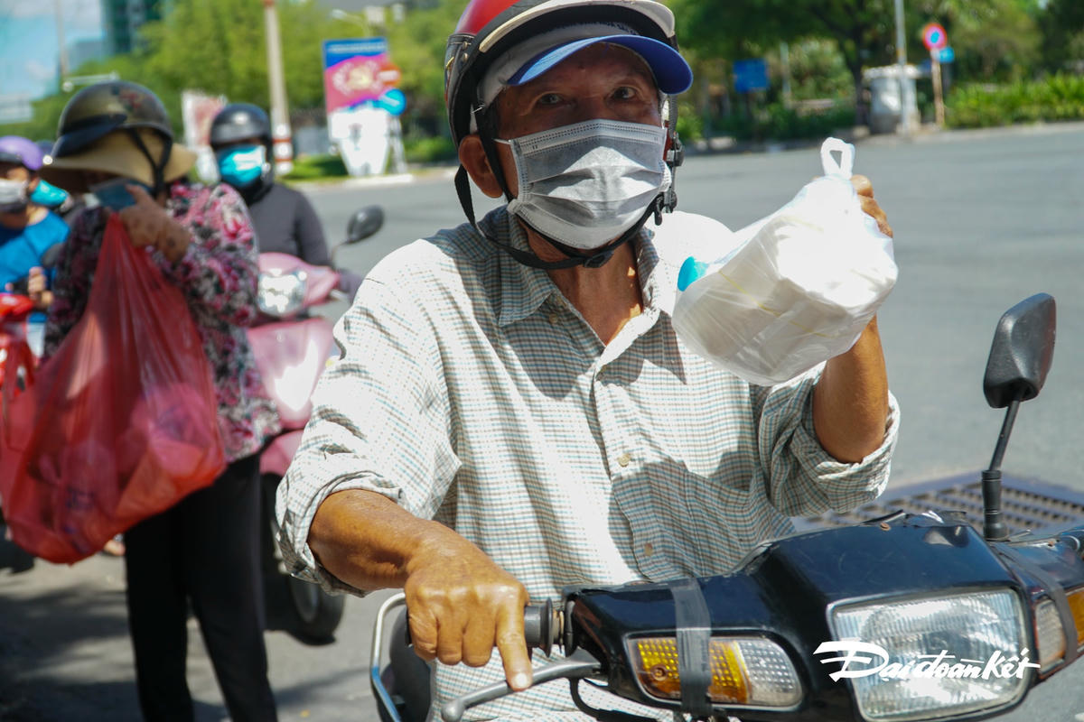 Nhận được phần cơm nóng hổi, người này đã giơ lên khoe khi thấy ống kính của phóng viên.