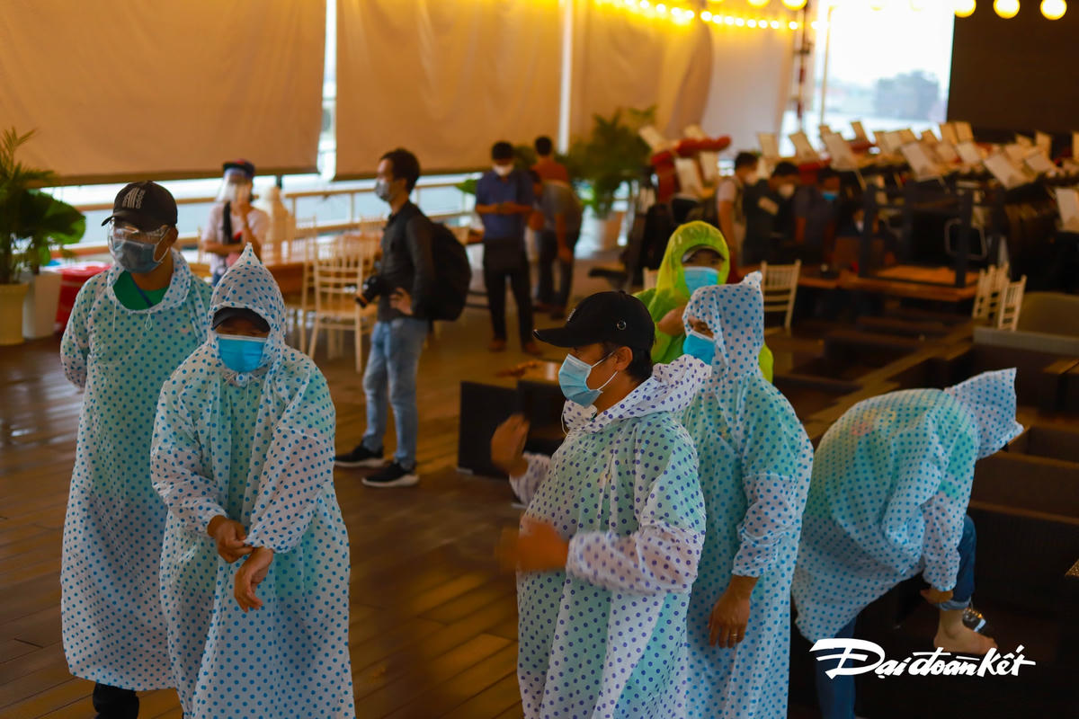 Một lực lượng khác mặc áo mưa sẽ vận chuyển hàng hóa từ bến ra xe.