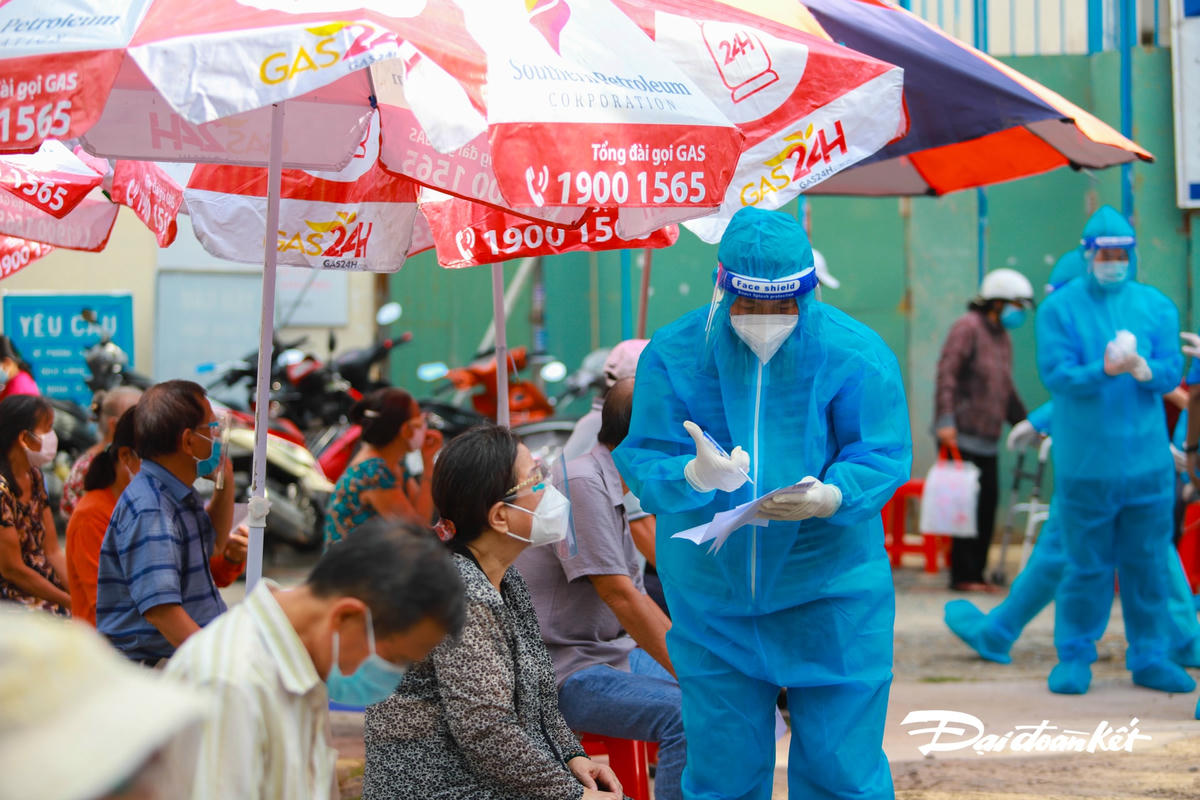 Nhân viên y tế hỗ trợ người dân điền thông tin.