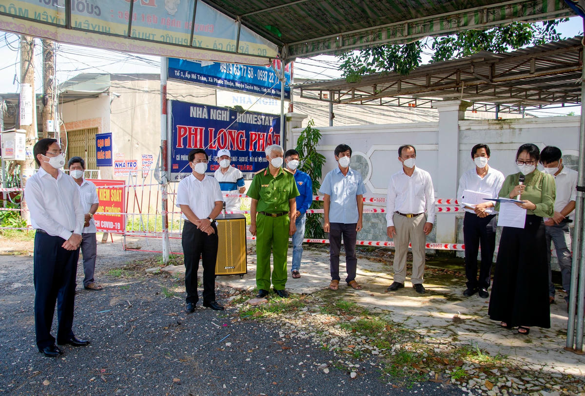 Ông Phạm Viết Thanh Bí thư tỉnh ủy Bà Rịa-Vũng Tàu (áo trắng, ngoài cùng bên trái) tham dự buổi công bố dỡ bỏ phong tỏa tại ấp Hồ Tràm. Ảnh: Báo BR-VT.