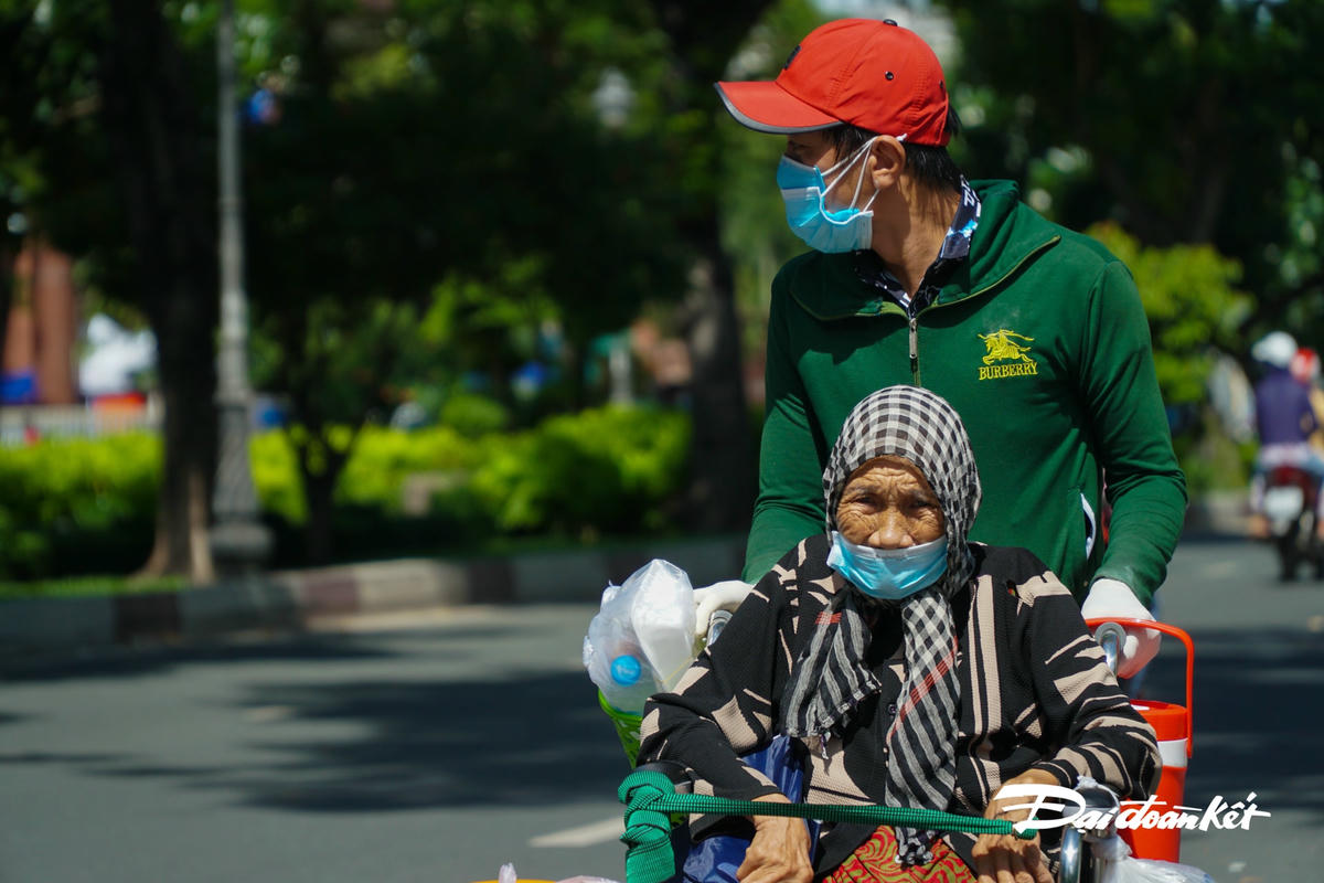 Người con ngoái nhìn theo hướng của nhóm phát cơm như muốn cảm ơn về phần cơm nóng đang cầm trên tay.