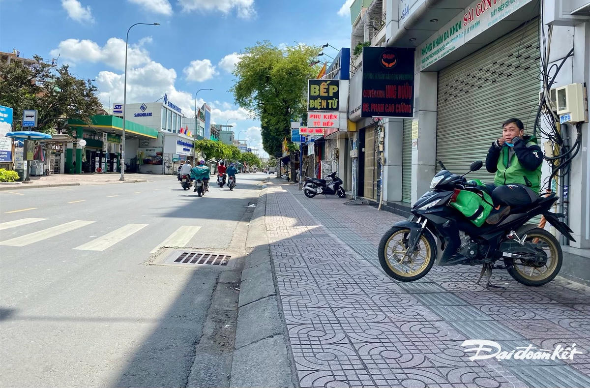 Một người xe ôm hành nghề lái xe công nghệ, mùa dịch lượng khách đi sụt giảm, ngồi “vắt vẻo” cả buổi mới có cuộc xe.