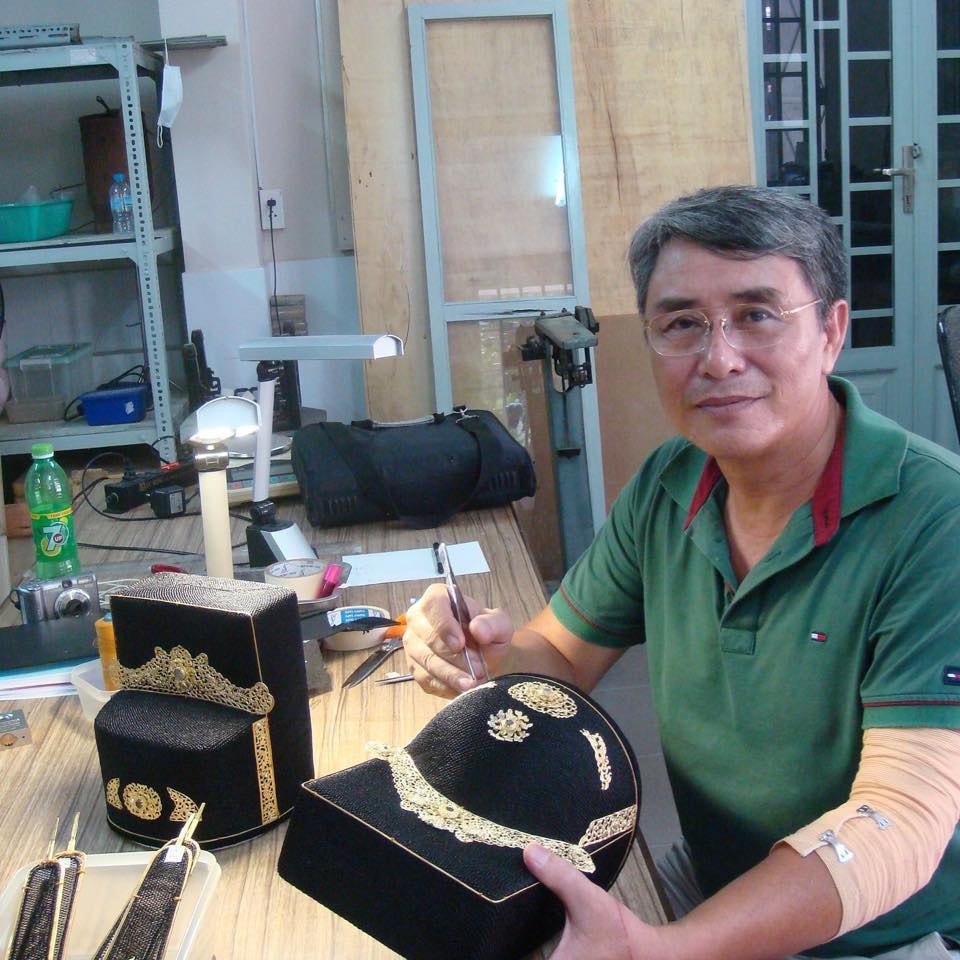 Ông Vũ Kim Lộc đang phục chế mũ.