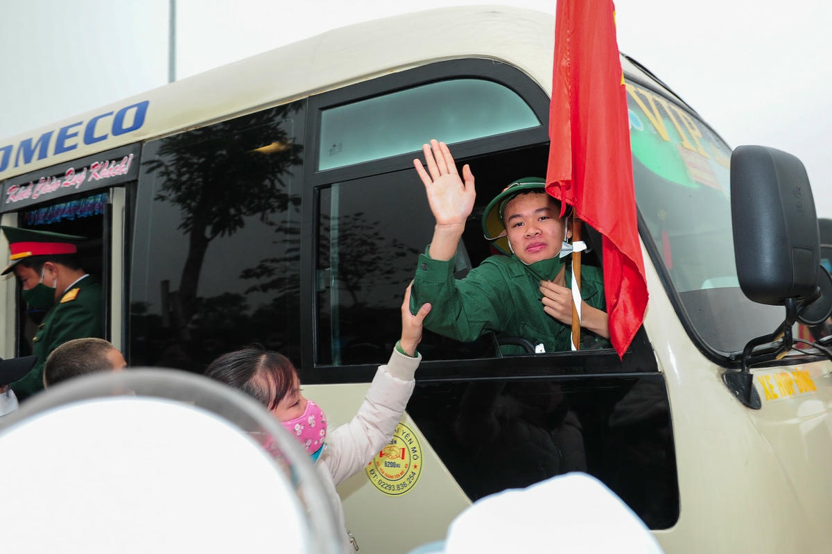 Một tân binh mỉm cười vẫy chào người thân trước khi lên đường.
