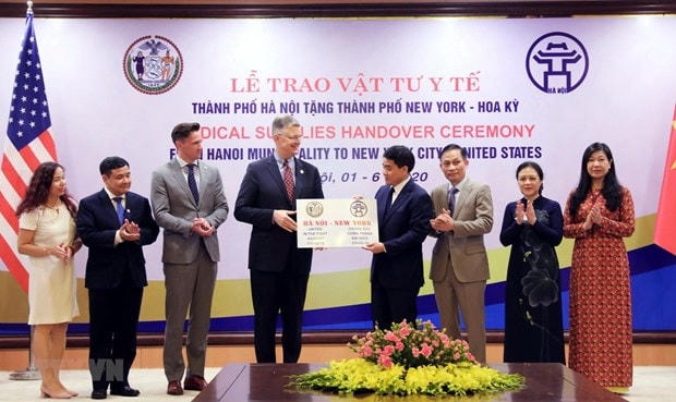 Chủ tịch UBND thành phố Hà Nội Nguyễn Đức Chung trao tượng trưng số vật tư y tế cho Đại sứ Hoa Kỳ tại Việt Nam Daniel J. Kritenbrink. (Ảnh: Lâm Khánh/TTXVN).